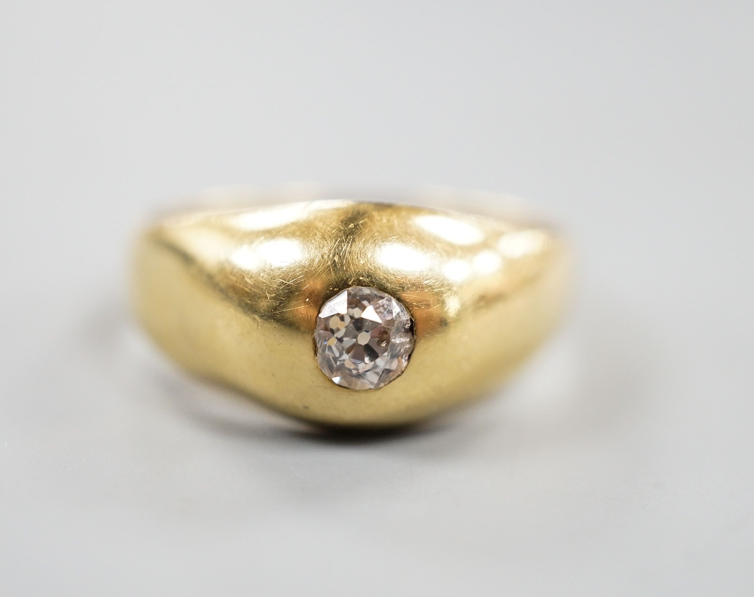 A yellow metal (stamped 18) and gypsy set solitaire diamond ring, size R, gross 5.6 grams.